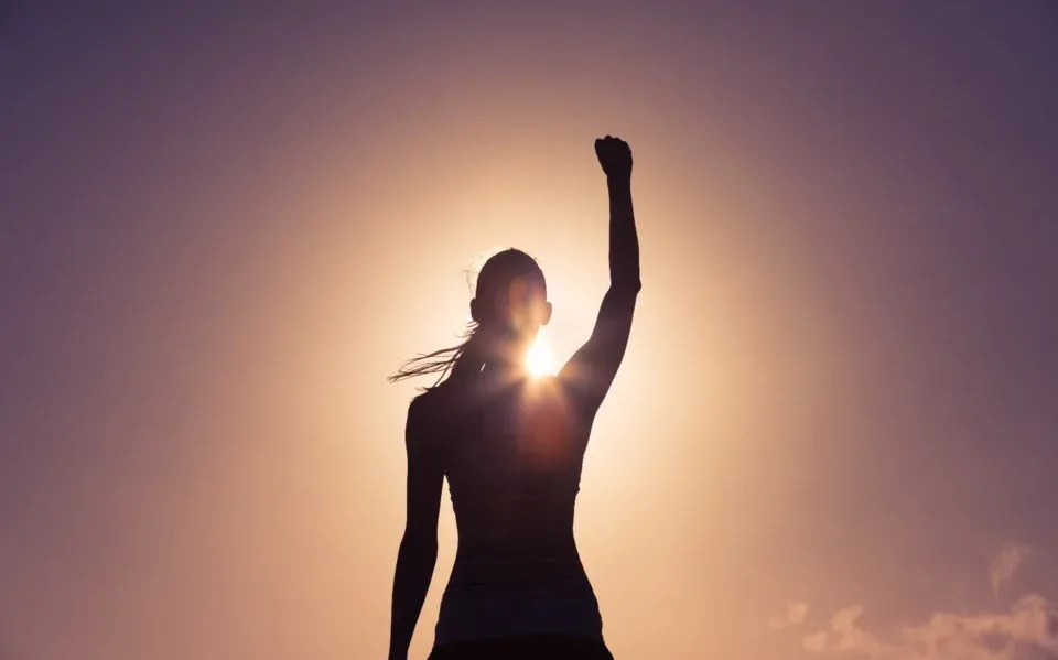 solar-appointment-setting woman with fist up in front of sun