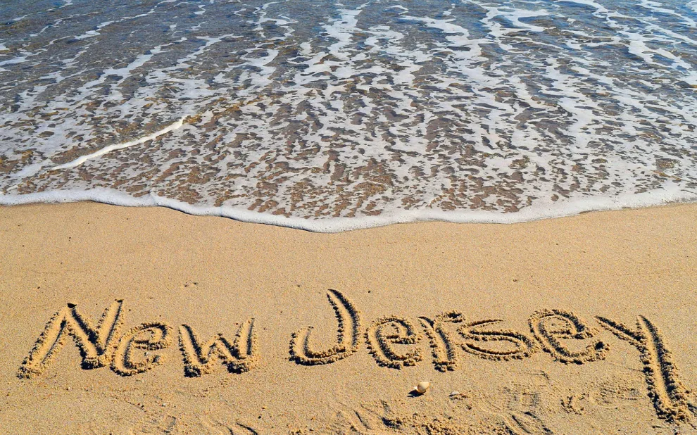 nj-solar-leads beach with new jersey written in sand